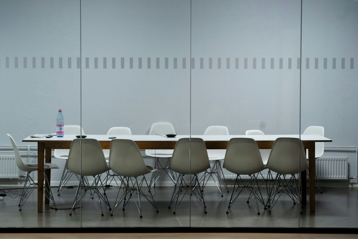 A long white meeting table with chairs in a quiet room