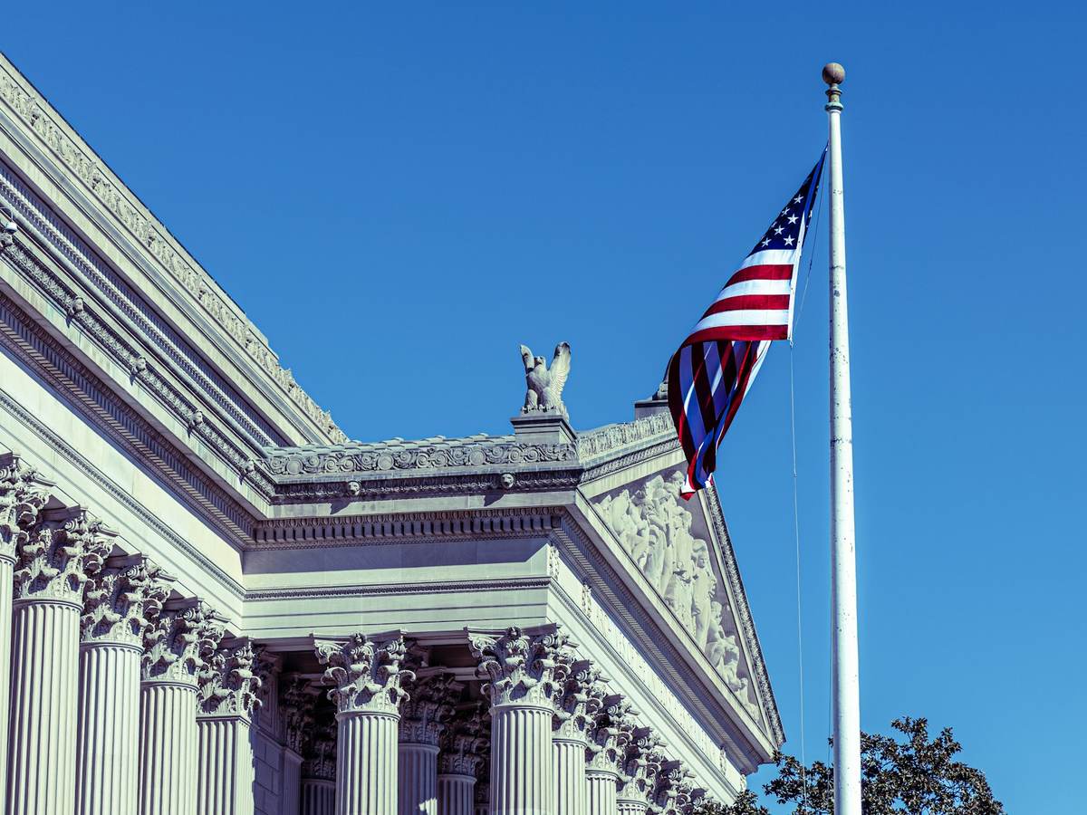 The American flag in front of a classical federal building
