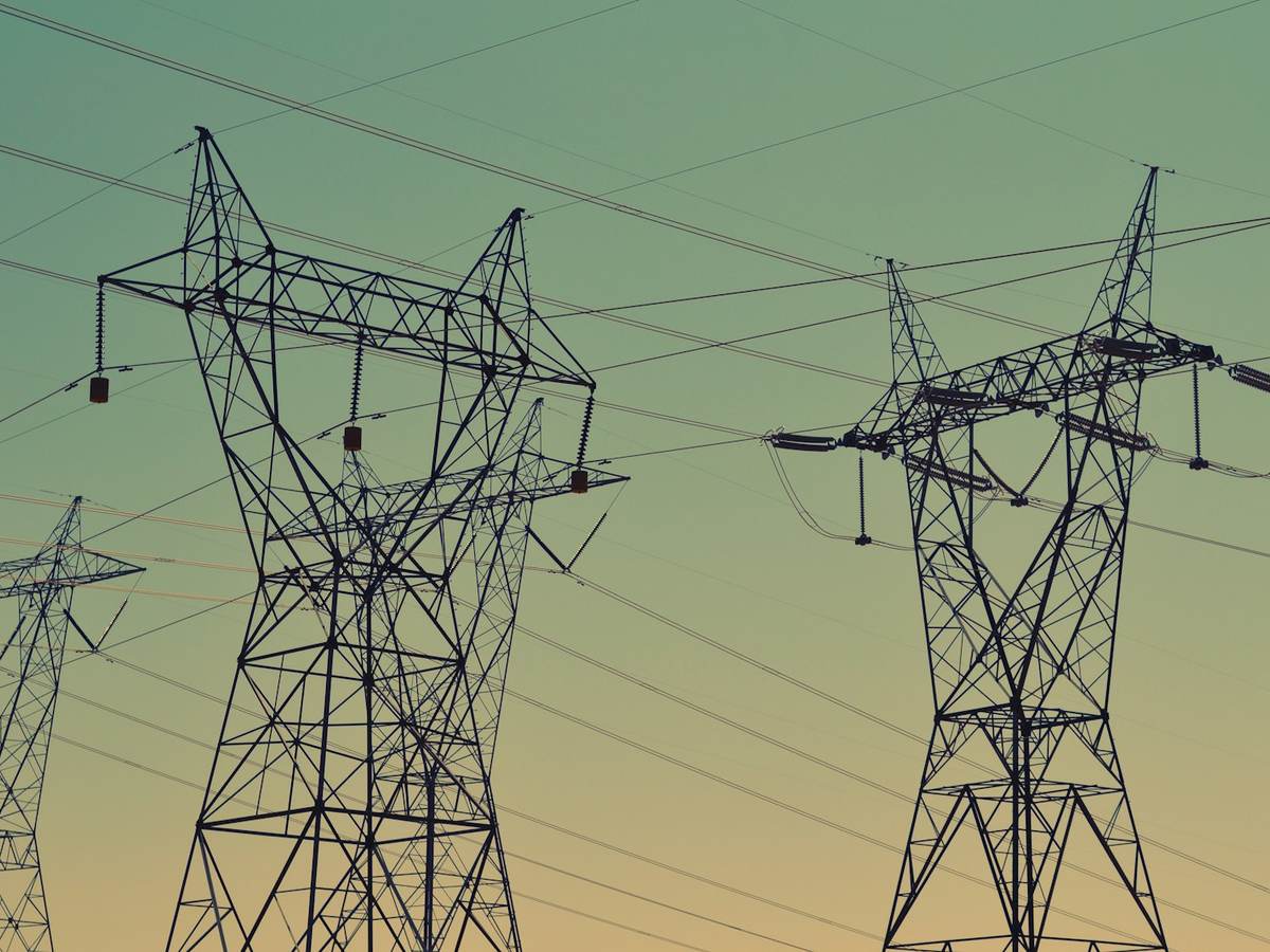 Transmission towers and power lines against an evening sky